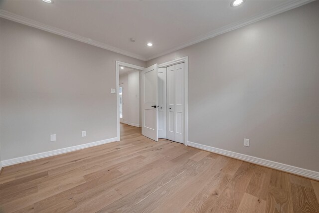 unfurnished bedroom with light hardwood / wood-style floors, a closet, and ornamental molding