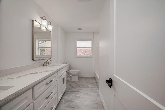 bathroom featuring a bathtub, vanity, and toilet