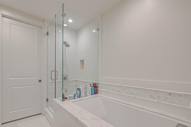 bathroom featuring tile patterned floors and separate shower and tub