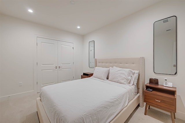 bedroom featuring a closet and light carpet