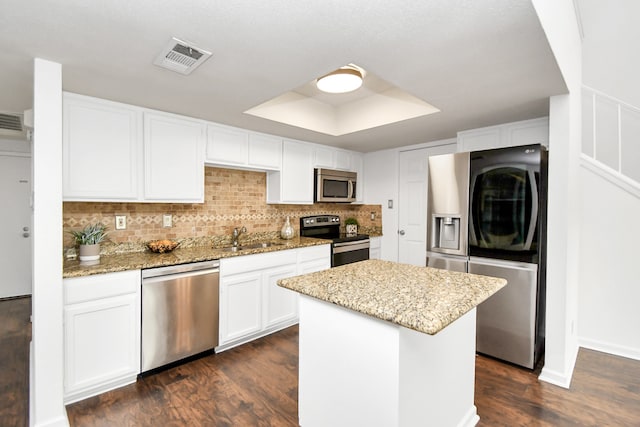 kitchen with white cabinetry, a center island, stainless steel appliances, and dark hardwood / wood-style flooring