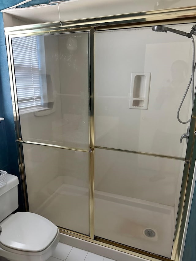 bathroom with toilet, an enclosed shower, and tile patterned floors