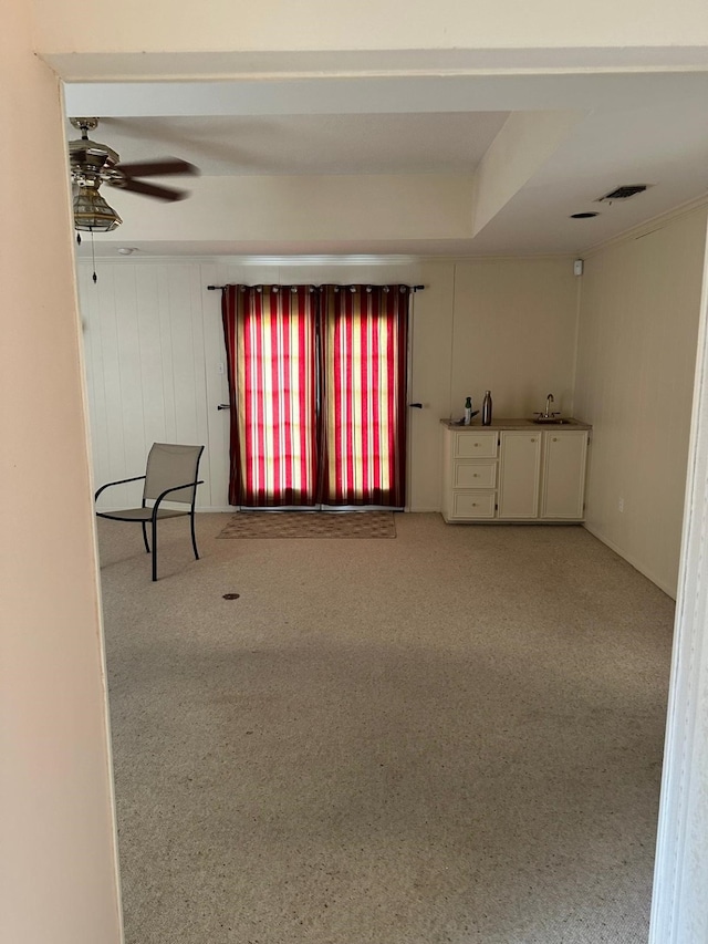 unfurnished living room featuring ceiling fan and carpet