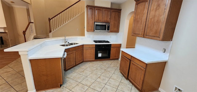 kitchen featuring sink, black appliances, kitchen peninsula, light tile patterned flooring, and a breakfast bar