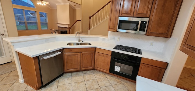 kitchen featuring black appliances, kitchen peninsula, sink, and light tile patterned flooring