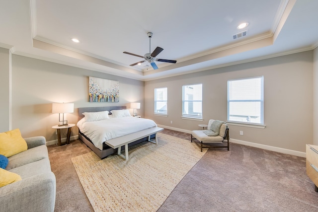 carpeted bedroom with a raised ceiling, visible vents, crown molding, and baseboards