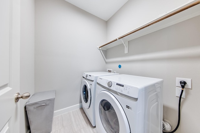 laundry area featuring laundry area, washing machine and dryer, and baseboards