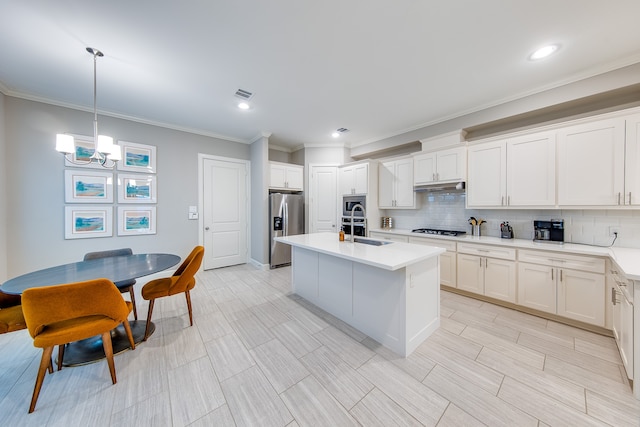 kitchen featuring appliances with stainless steel finishes, decorative light fixtures, decorative backsplash, white cabinetry, and sink