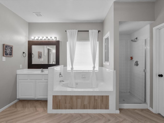 bathroom featuring vanity, parquet flooring, and shower with separate bathtub