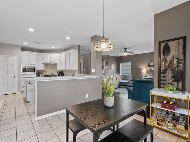 dining room with ceiling fan with notable chandelier and light tile patterned floors