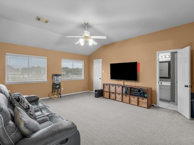 living room featuring vaulted ceiling, light colored carpet, and ceiling fan