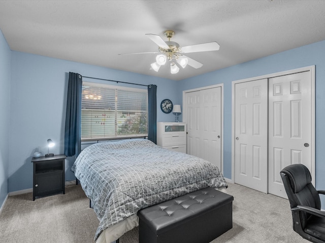 bedroom featuring multiple closets, carpet, and ceiling fan