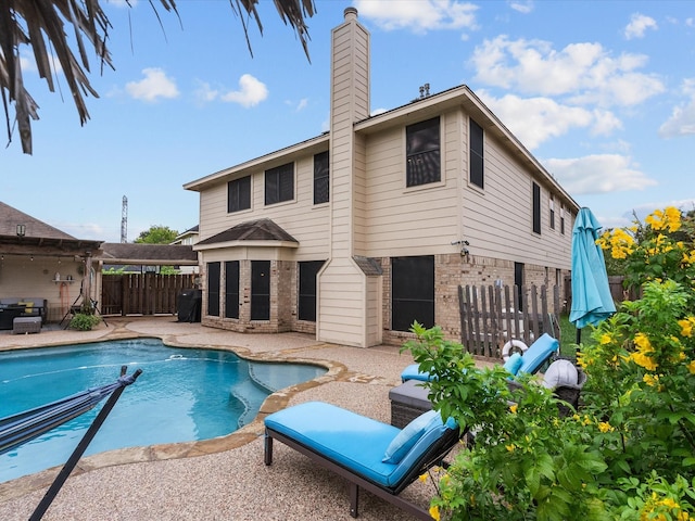 back of house featuring a fenced in pool and a patio area