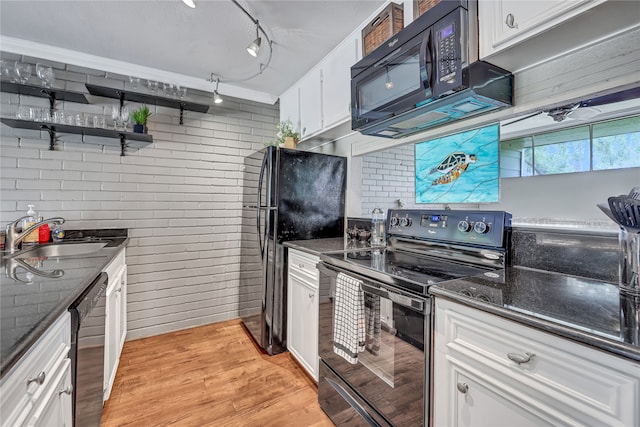 kitchen with brick wall, white cabinetry, sink, rail lighting, and black appliances