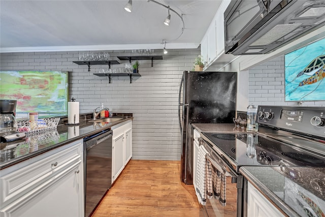 kitchen with brick wall, white cabinetry, rail lighting, and black appliances