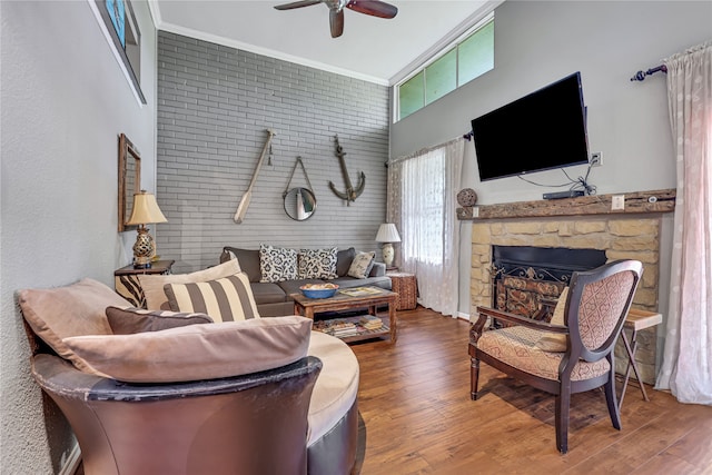 living room featuring a fireplace, brick wall, ceiling fan, and wood-type flooring