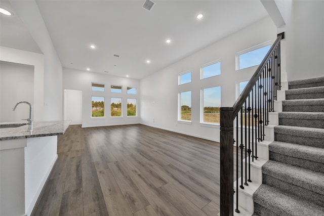 unfurnished living room with hardwood / wood-style floors and sink