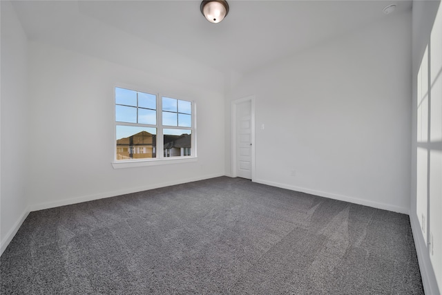 spare room with dark colored carpet