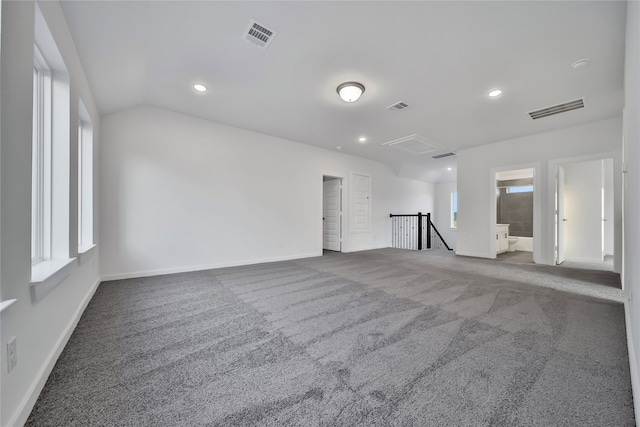 carpeted spare room with vaulted ceiling