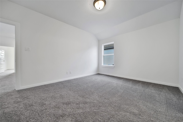 empty room with carpet floors and vaulted ceiling