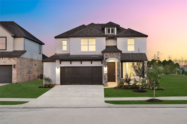 view of front of property with central AC unit, a garage, and a lawn