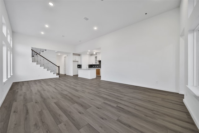 unfurnished living room with dark wood-type flooring