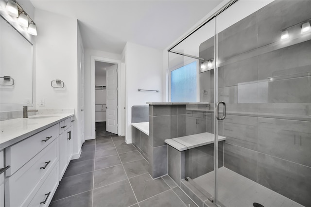 bathroom featuring a shower with door, vanity, and tile patterned flooring