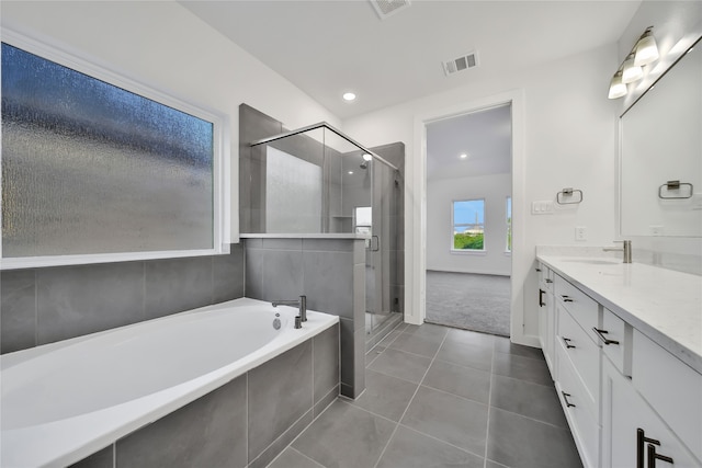 bathroom featuring tile patterned flooring, vanity, and separate shower and tub