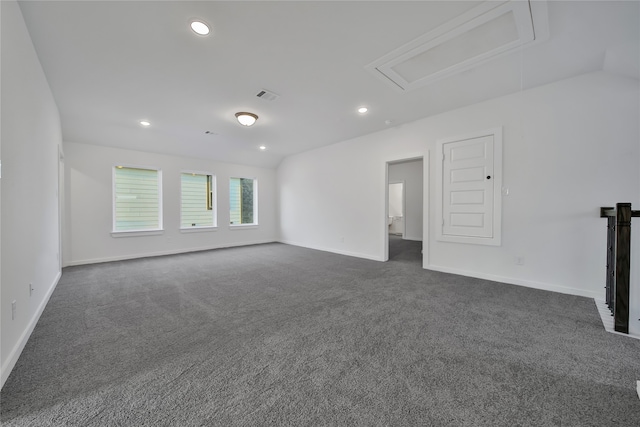 unfurnished room with dark colored carpet and lofted ceiling