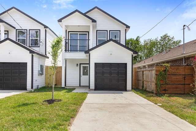 view of front of home with a garage, a balcony, and a front yard