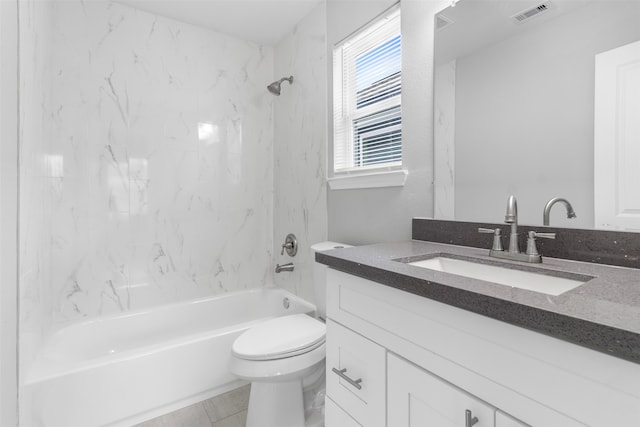 full bathroom with tiled shower / bath, toilet, tile patterned floors, and vanity