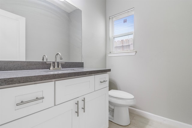 bathroom featuring tile patterned flooring, toilet, and vanity