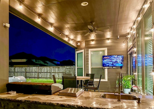 patio at twilight with ceiling fan and sink