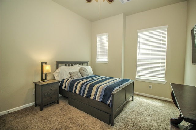 carpeted bedroom featuring multiple windows and ceiling fan