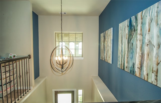 hallway with plenty of natural light and an inviting chandelier