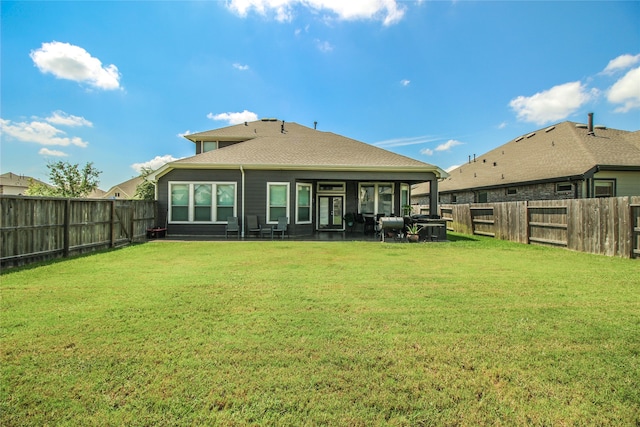 rear view of house featuring a yard and a patio