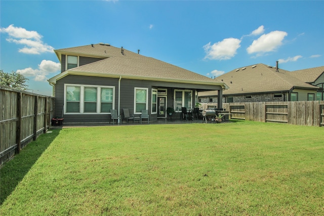 back of house with a patio and a lawn