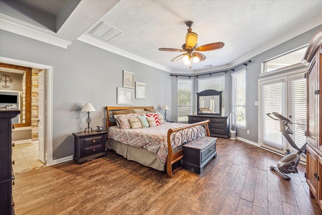 bedroom with dark hardwood / wood-style flooring, ornamental molding, ensuite bath, and ceiling fan