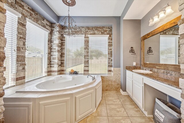 bathroom featuring a washtub, a healthy amount of sunlight, vanity, and tile patterned floors