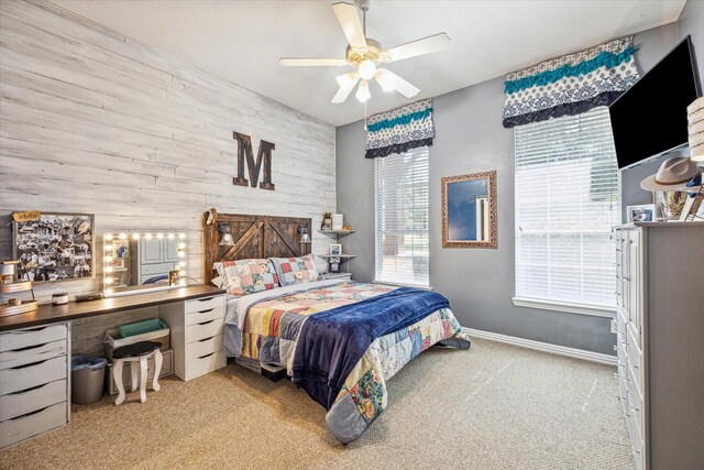 carpeted bedroom with ceiling fan and wooden walls