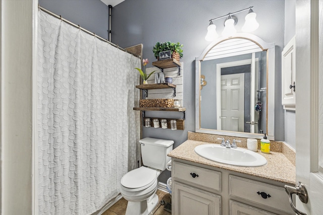 bathroom featuring toilet, vanity, curtained shower, and tile patterned floors