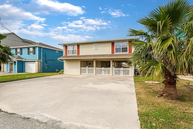 view of front facade with a carport, a front yard, and a garage