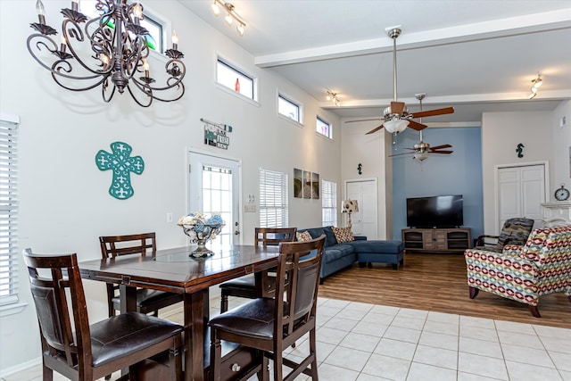 tiled dining area with beamed ceiling and ceiling fan with notable chandelier