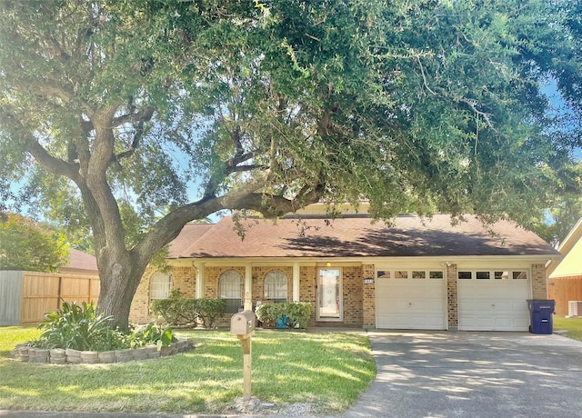 ranch-style home with an attached garage, driveway, fence, and brick siding