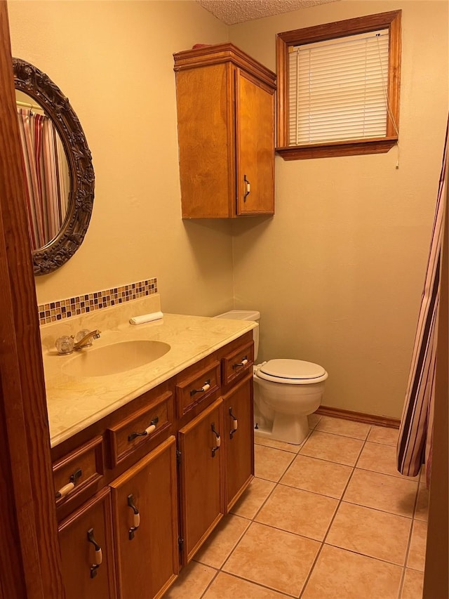 bathroom featuring toilet, tile patterned floors, and vanity