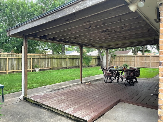 wooden deck featuring a fenced backyard, outdoor dining area, and a lawn