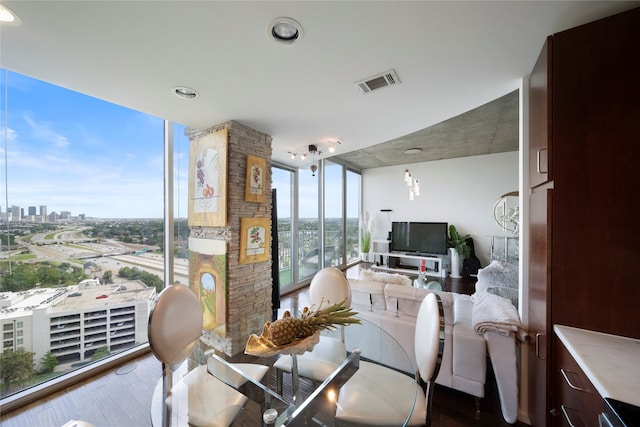 interior space with a stone fireplace, wood-type flooring, and expansive windows