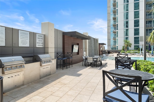 view of patio / terrace with grilling area, area for grilling, and a community pool