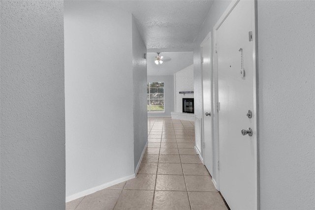 hallway featuring light tile patterned floors and a textured ceiling