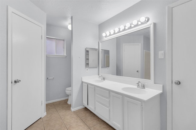 bathroom featuring tile patterned flooring, vanity, toilet, and a textured ceiling